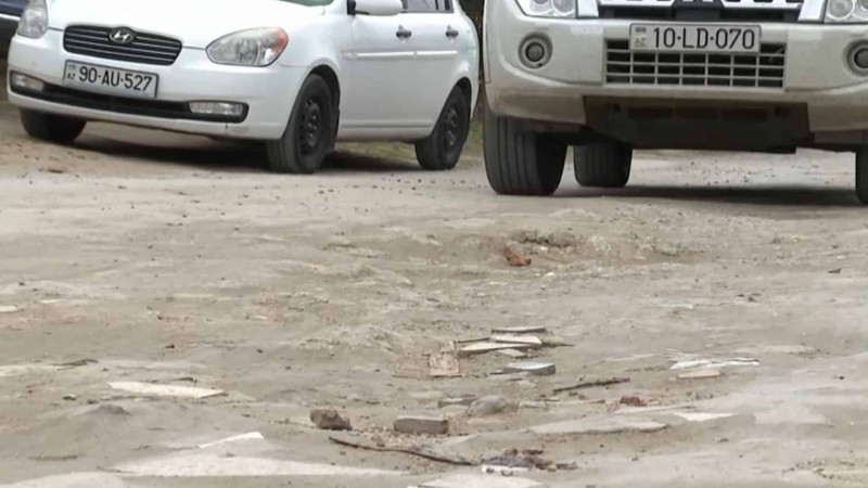 Binə qəsəbəsində yol iki hissəyə bölünüb: biri asfaltla örtülüb, ikincisi isə toz-torpaqdır