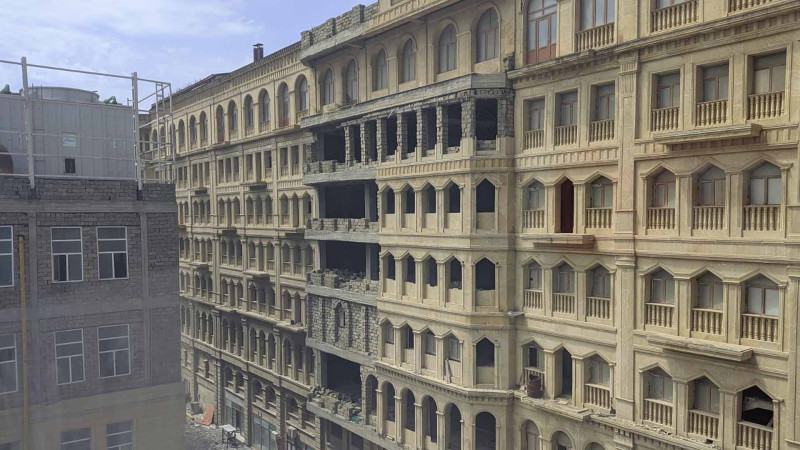 Bakıda ticarət mərkəzinin binasının fasadından qopan daşlar yoldan keçənlərin başına uçur