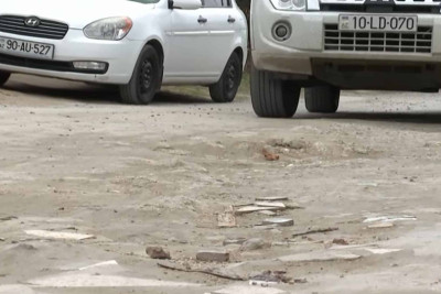 Binə qəsəbəsində yol iki hissəyə bölünüb: biri asfaltla örtülüb, ikincisi isə toz-torpaqdır