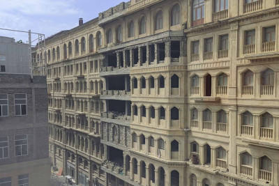 Bakıda ticarət mərkəzinin binasının fasadından qopan daşlar yoldan keçənlərin başına uçur