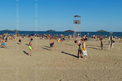 Suyu çirkli olan çimərlik insanlarla doludur